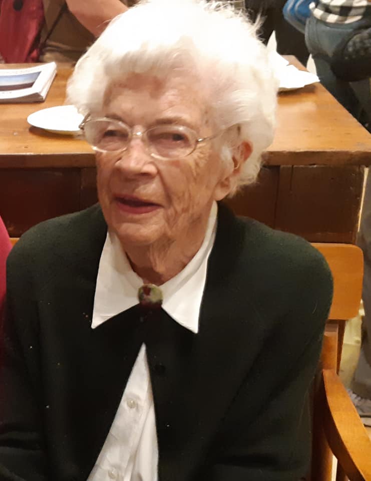 Grandmother in a white shirt with a black cardigan. smiling in picture